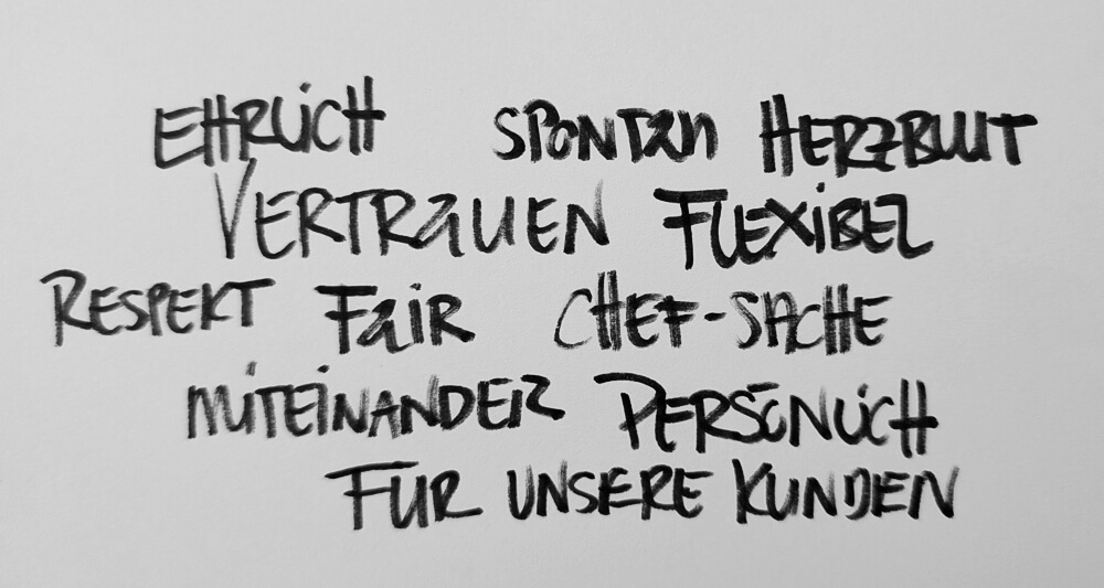 Zettel mit den Worten ehrlich, spontan, Herzblut, Vertrauen, Chef-Sache, Respekt, persönlich und weiteren Worten